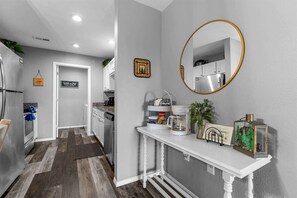 A modern kitchen with a white countertop, a coffee maker, and a decorative mirror. - Spruce Valley Condo 3BDR (Branson)
