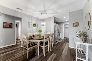 A modern kitchen with a central island, stainless steel appliances, and a dining area with a round table and chairs. - Spruce Valley Condo 3BDR (Branson)
