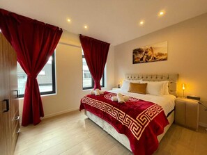 A hotel room with a bed, a nightstand, a lamp, and a painting on the wall. - Lange Leemstraat Home Near Station (Antwerp)