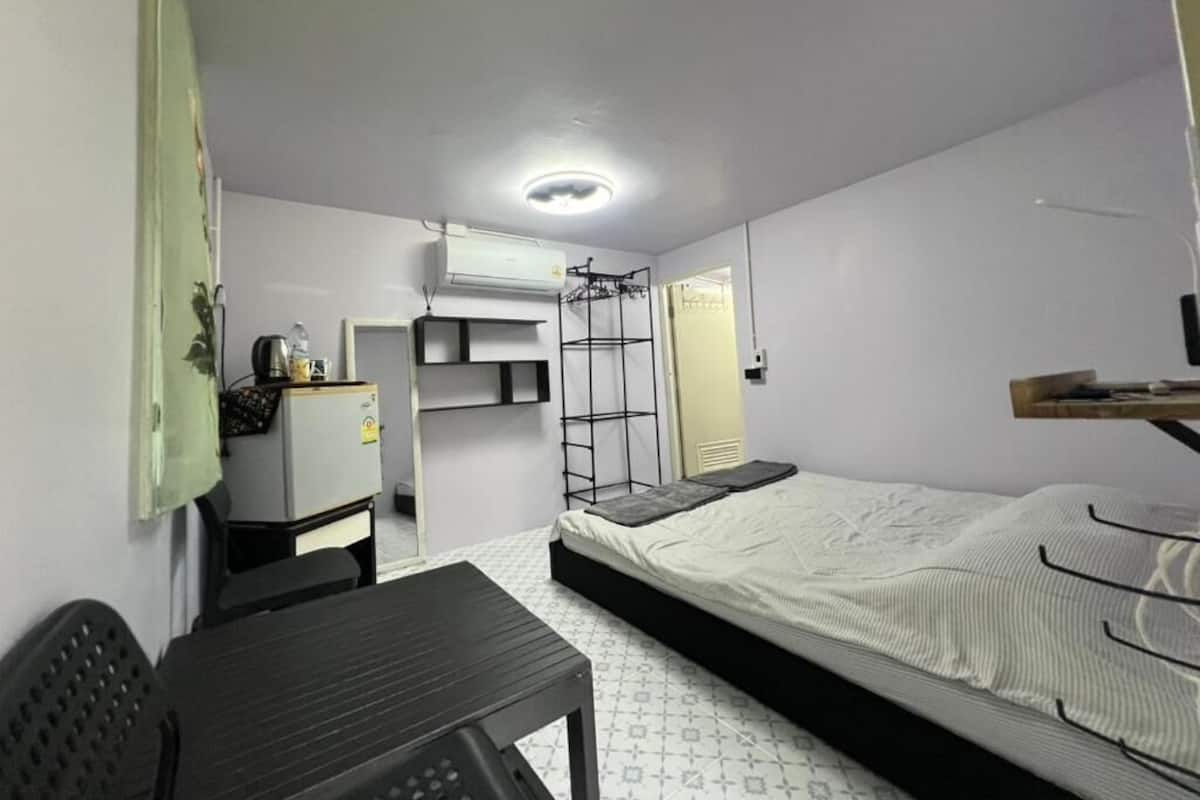 Una habitación pequeña con cama, escritorio y silla.