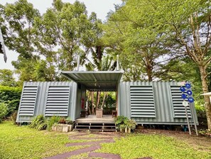 A structure with a covered entrance, steps leading up to it, and a sign with symbols.