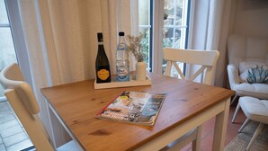Una mesa de madera con una revista, una botella y un florero con flores secas.