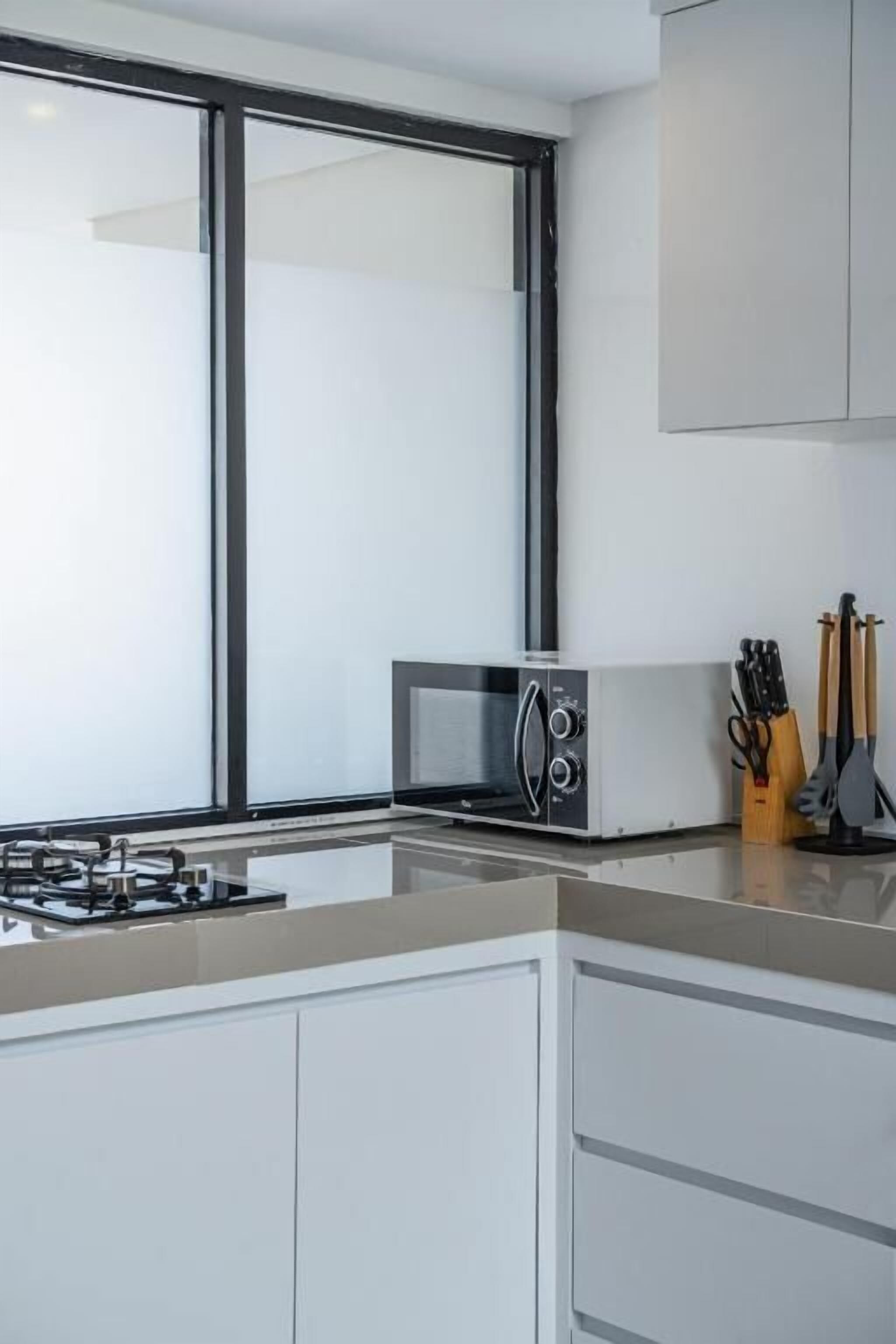 Una cocina moderna con estufa a gas, microondas y armarios.