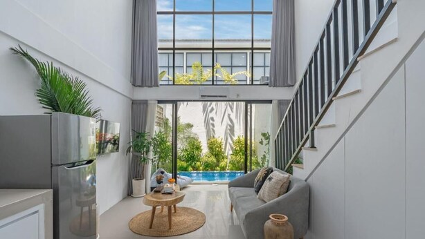 A modern kitchen with a refrigerator, a dining table, and a sofa. - Wolu 1BR Canggu Pool Villa Parking Wifi (Bali)