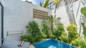 A small, private pool area with a tiled edge, surrounded by lush greenery and a white wall with a window. - Wolu 1BR Canggu Pool Villa Parking Wifi (Bali)