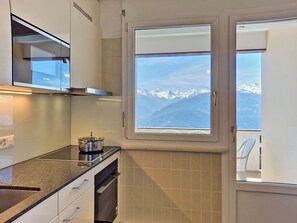 Eine Küche mit Blick auf schneebedeckte Berge durch ein Fenster.