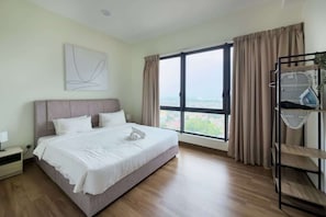 Quarto de hotel moderno com uma cama grande, uma mesa de cabeceira, uma obra de arte na parede, uma janela com cortinas e vista para a cidade.