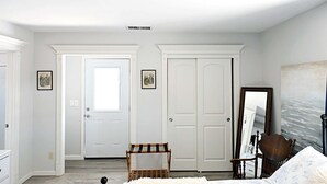 Une chambre à coucher avec un lit, une chaise, une armoire et une porte.