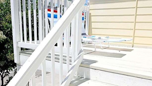 Un escalier en bois blanc menant à une porte de garage.