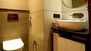 Un baño con inodoro, lavamanos, espejo y ducha.