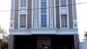 Un edificio con un letrero que dice 'HOTEL THE REPUBLIC' y un letrero debajo que indica 'HOTEL THE REPUBLIC LAC-ROOMS'.
