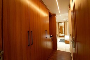 A hallway with wooden wardrobes, a bed, and a bathroom visible in the background. - HOTEL THE REPUBLIC (Zirakpur)
