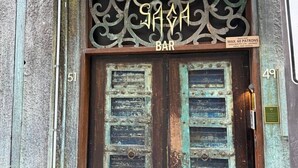 A bar entrance with ornate metalwork, a sign indicating 'MAX. 60 PATRONS,' and a door number '49.' - Modern 2BR 3 min to Central Station FREE Parking (Chippendale)
