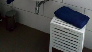 Un bagno con lavandino bianco, specchio e porta asciugamani.