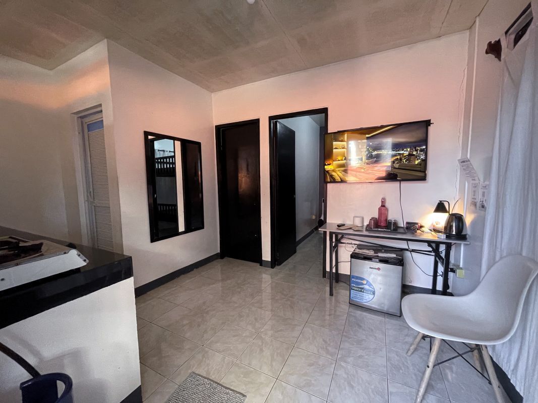 A compact living space with a kitchenette, a dining area, and a seating area.