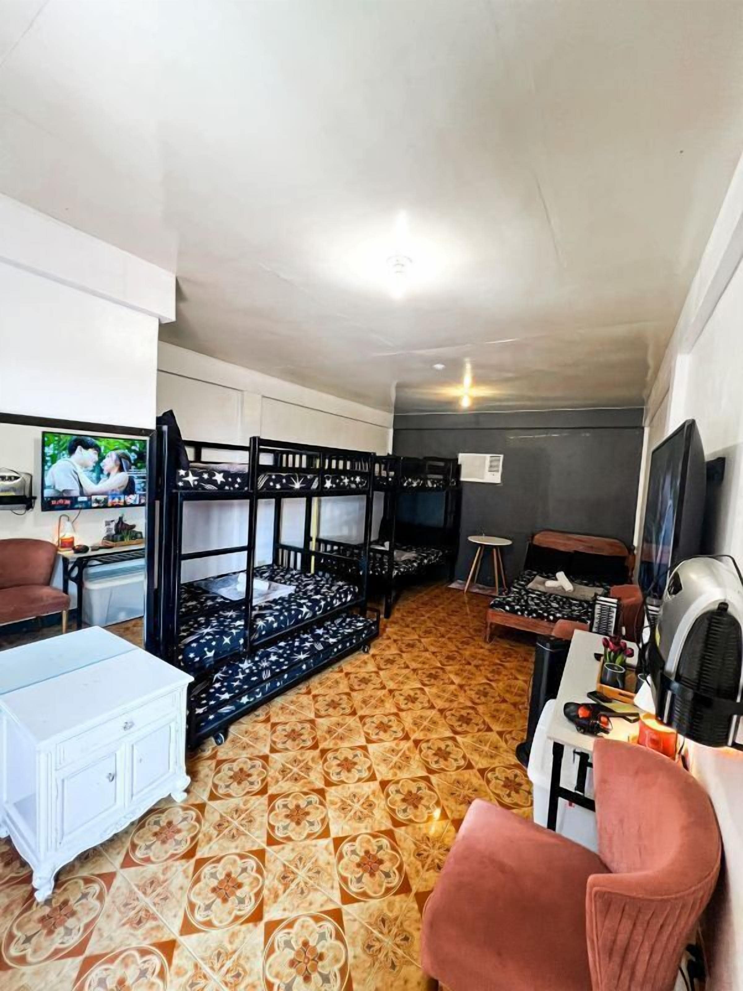 A room with bunk beds, a white cabinet, a desk, and a chair.