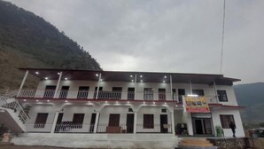 A two-story building with a balcony, a staircase, and a sign advertising rooms for rent. - Swastik Hotel and Restaurant (Banglo Ki Kandi)