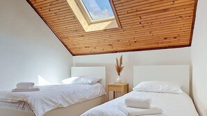A bedroom with two beds, a skylight, and a wooden ceiling. - Vacation home Orba by Interhome (Imotski)