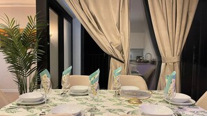 A dining table set with plates, glasses, and cutlery, surrounded by chairs. - Central Family Base in Antwerp (Antwerp)