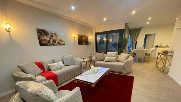 A modern living room with two sofas, a coffee table, and a red rug. - Central Family Base in Antwerp (Antwerp)