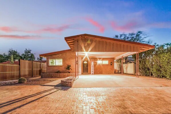 Une maison moderne dotée d’un garage fermé, d’une façade en briques et d’une allée pavée.