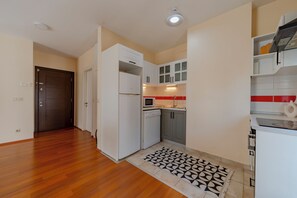 A compact kitchen with white cabinets, a microwave, and a dishwasher. - Spacious One-Bedroom Apartment with Bosphorus View (İstanbul)