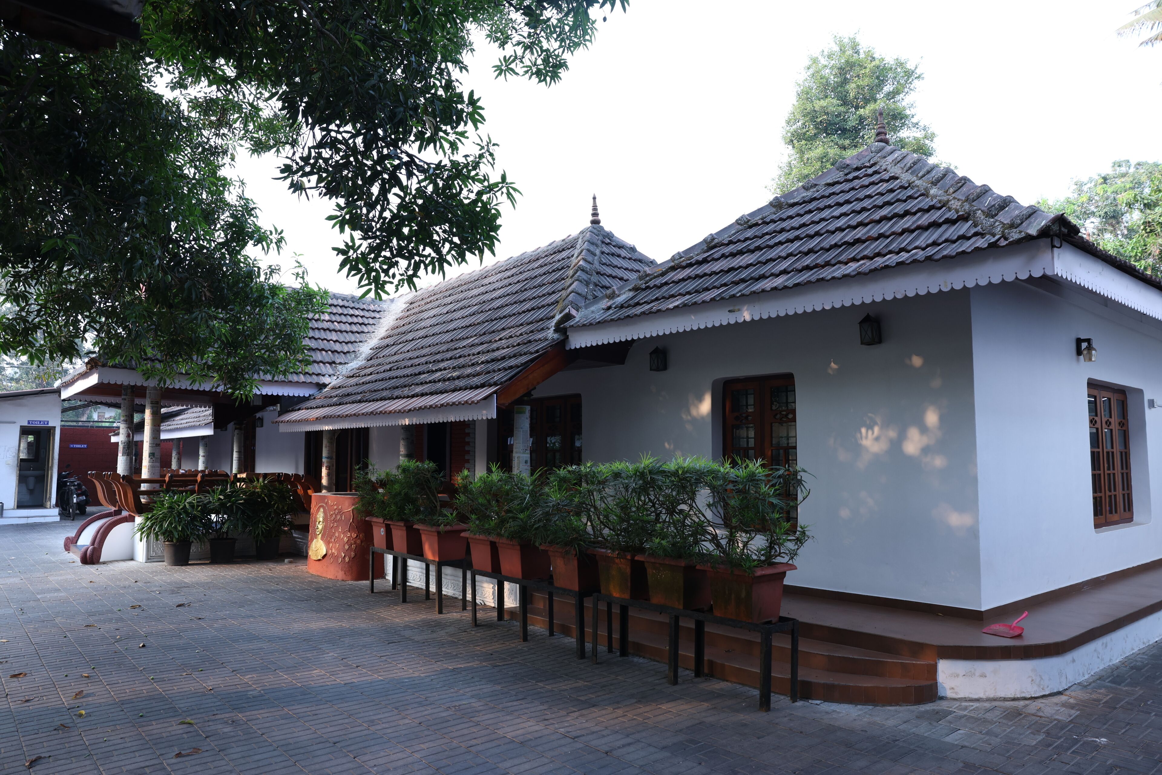 A traditional building with a tiled roof, a wooden staircase, and potted plants.