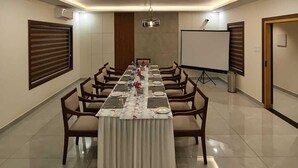 A conference room with a long table, chairs, a whiteboard, and a projector screen. - KABANI HERITAGE (Aluva)