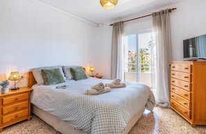 A bedroom with a bed, bedside lamps, a dresser, a TV, and a balcony view. - Appartement Don Pepe - Javea, Costa Blanca (Javea)