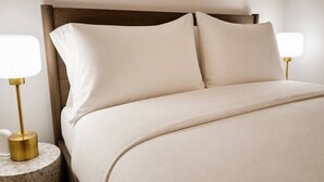 A bed with a wooden headboard, two bedside tables with lamps, and a plain wall. - Brick & Bed - Luxury Downtown Loft (St. Louis)