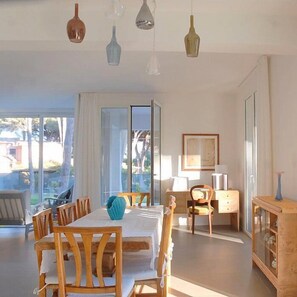 Ein geräumiges Zimmer mit Esstisch, Stühlen, einem Schrank und einem Schreibtisch.