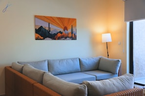 A living room with a sofa, a lamp, and a painting on the wall.