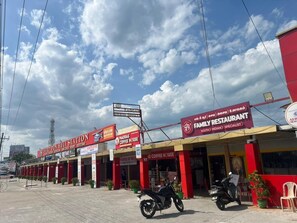 A commercial area with multiple storefronts, including a family restaurant and a coffee house.