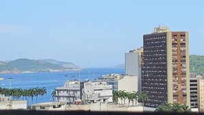 A coastal cityscape with buildings, a clear sky, and a view of the sea. - Cozy●Sea View●Beach●Subway●Wi-Fi● Air Conditioning●24H Concierge●Secure (Rio de Janeiro)