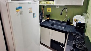 A compact kitchen with a refrigerator, microwave, sink, and stove. - Cozy●Sea View●Beach●Subway●Wi-Fi● Air Conditioning●24H Concierge●Secure (Rio de Janeiro)