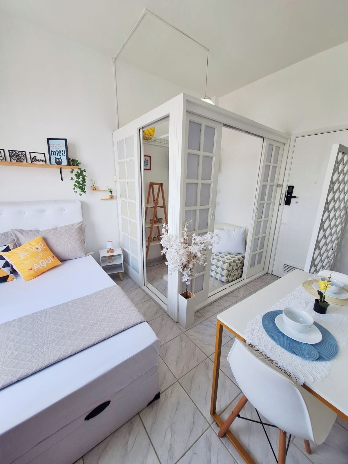 A bedroom with a bed, bedside table, and a small table with a chair.