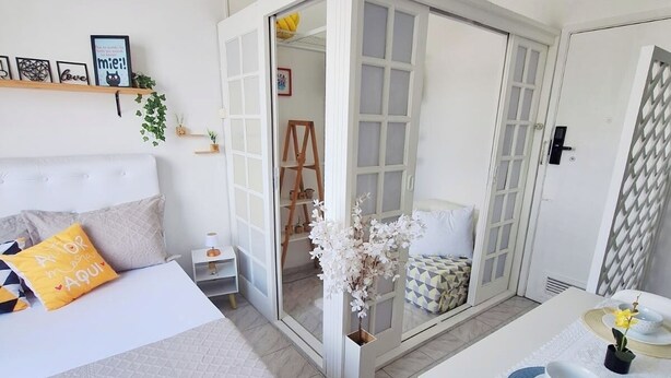 A bedroom with a bed, bedside table, and a small table with a chair. - Cozy●Sea View●Beach●Subway●Wi-Fi● Air Conditioning●24H Concierge●Secure (Rio de Janeiro)