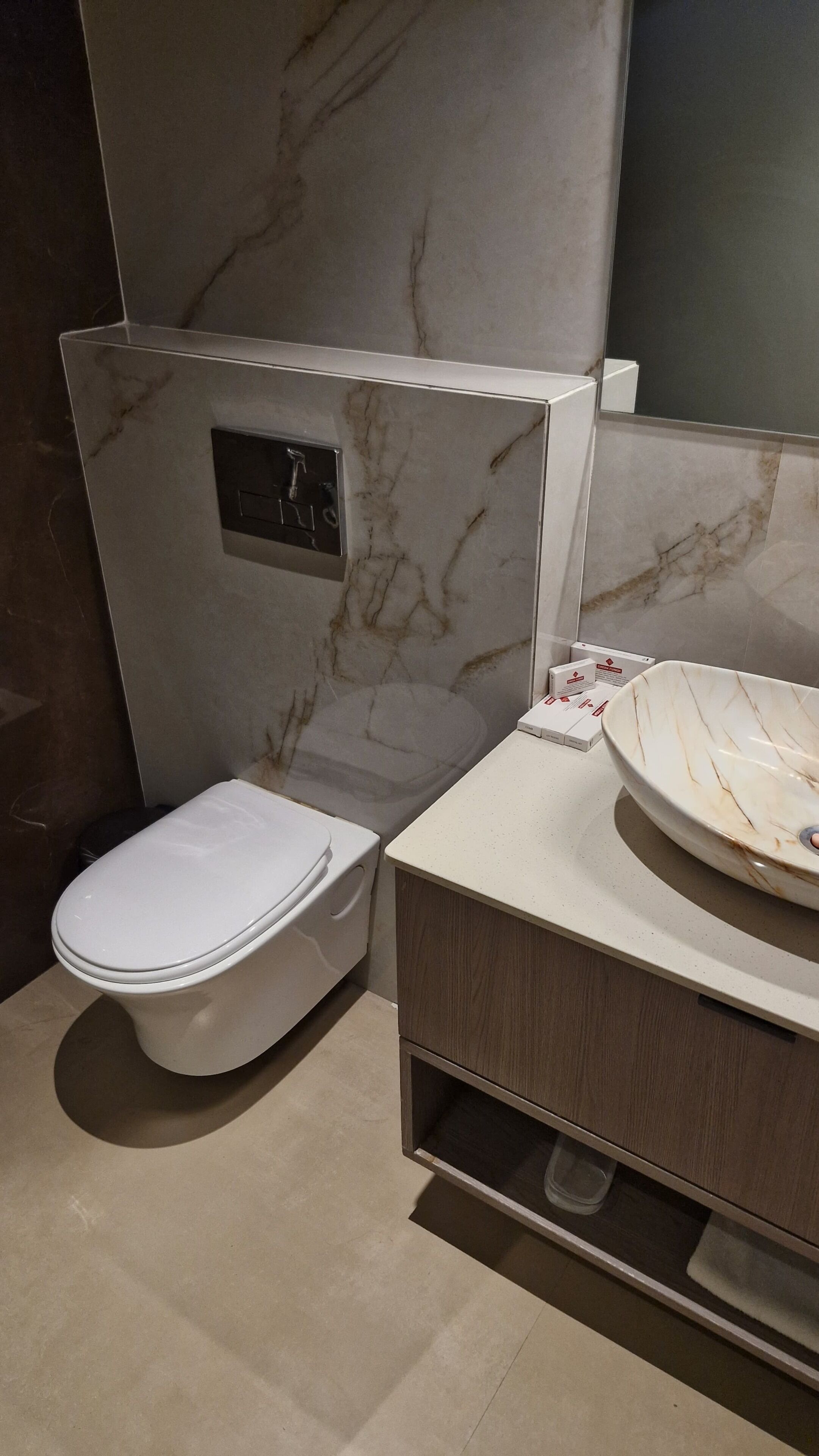 A modern bathroom with a toilet, a sink, and a mirror.