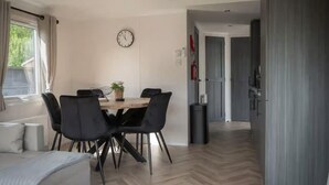 En modern inredning med ett matbord, stolar, en klocka och utsikt över en hall.