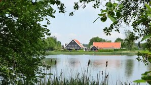 En utsikt över en sjö med ett hus och en ladugård.