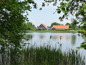 A lakeside view with a house and a barn. - Cozy Heinkenszand Retreat (Heinkenszand)