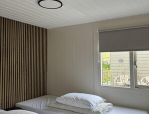 A room with a bed, a window with a view, and a ceiling with a circular light fixture. - Modern Coastal Stay in Zoutelande (Zoutelande)