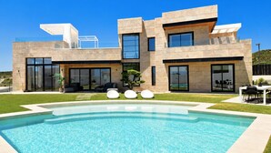 A modern two-story house with a swimming pool, large windows, and a well-maintained lawn. - Luxury Modern Villa with Private Pool and Rooftop Terrace (Estepona)