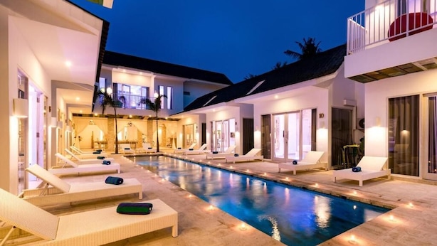 A swimming pool with lounge chairs and a well-lit building facade. - Cocotoa Boutique Hotel and Villa (Gili Trawangan)
