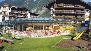 Hotel con terraza al aire libre, tobogán y vistas a la montaña.