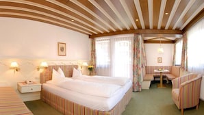 Una habitación de hotel con una cama grande, un sofá, una mesita y una silla.