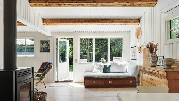 Una habitación acogedora con chimenea, un banco y una mesa de comedor.