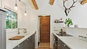 Una cocina con vigas de madera, una puerta de madera y un cráneo de venado montado.