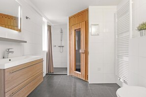 Ein modernes Badezimmer mit einem Holzkosmetikschrank, einer Dusche und einer Toilette.