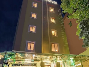 A multi-story hotel with illuminated windows and a sign that reads 'HOUSE'. - Townhouse RCC Park View Inn (Hyderabad)